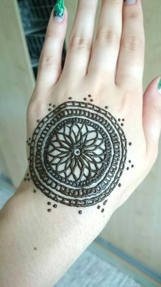 a woman's hand with henna tattoos on it