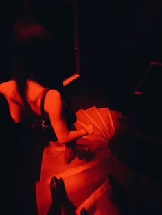 a woman laying on the floor with an umbrella in her hand and red light coming from behind her