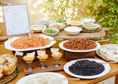 a table filled with lots of different types of food on plates next to each other