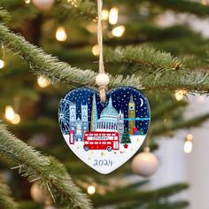 a christmas ornament hanging on a tree in front of a lite - up building