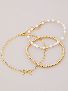 The 3 Pack Bow Gold Bracelet Set, designed for plus-sized women to fit comfortably, features beaded and pearl accents, complemented by 18k gold dipping to ensure durability and prevent tarnishing. Skirt And Top Dress, Gold Bracelet Set, Pearl Bow, Pearls Diy, Bow Bracelet, Gold Dipped, Romper With Skirt, Stretch Bracelet, Christmas List