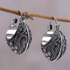 Finely crafted earrings showcase Balinese design as Made Sriasih creates opulent hoops. Sterling arabesques swirl amid silver petals and granules in contemporary heirloom earrings. .925 Sterling silver Silver Fusion Dangle Hoop Earrings, Elegant Round Earrings With Artistic Design, Ornate Handmade Hoop Earrings, Handmade Ornate Hoop Earrings, Elegant Silver Hoop Earrings With Oxidized Finish, Silver Artisan Earrings With Artistic Design, Artisan Silver Earrings With Artistic Design, Silver Sterling Silver Fusion Hoop Earrings, Silver Hoop Earrings With Oxidized Finish For Wedding