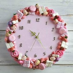 a clock made out of pink and white candies