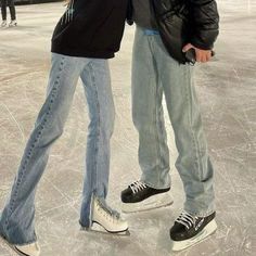 two people are standing on an ice rink