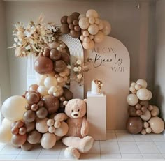 a teddy bear surrounded by balloons and flowers in a room with a sign that says, we can bear my way