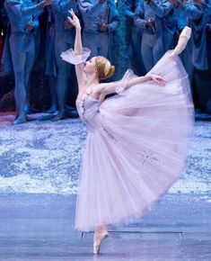 the ballerina is wearing a pink tutu while performing in front of a group of dancers