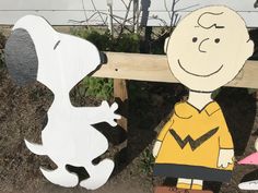 a couple of wooden cut outs of charlie brown and his dog