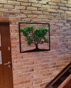 a red brick wall with a tree cut out on it and an escalator