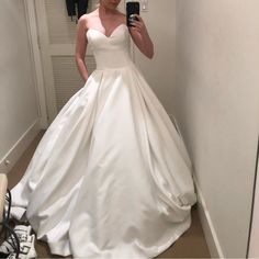 a woman is taking a selfie in her wedding dress while looking into the mirror