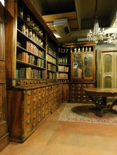 an old library with lots of books on shelves and a chandelier hanging from the ceiling