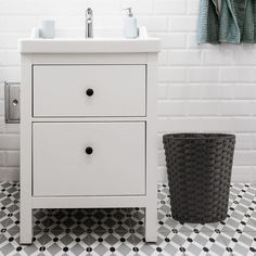 a white sink sitting next to a black trash can