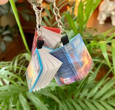 a book shaped keychain hanging from a plant