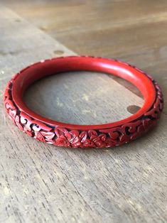 Unique Chinese ethnic style vintage Carved Floral Pattern Cinnabar Lacquer Bangle from the 70s. Beijing carved cinnabar lacquer ware is a traditional Chinese arts and crafts. By carving landscapes, bird-flowers and human figures on the moulded body of an article which is coated with relatively thick layers of lacquer. This arts crafting has been started far back during Han (漢) Dynasty (B.C. 206 - 220 A.D.). The processes involved in carved cinnabar lacquer ware are very complicated. In general, Cinnabar Jewelry, Chinese Bracelet, Chinese Arts And Crafts, Red Bangles, Traditional Chinese Art, Antique Jade, Thick Layers, Vintage Bangle Bracelets, Human Figures