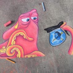 a drawing of an octopus and a fish on the ground next to crayons