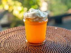 a glass jar filled with liquid sitting on top of a wicker tablecloth covered table