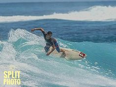 a man riding a surfboard on top of a wave in the ocean with blue water