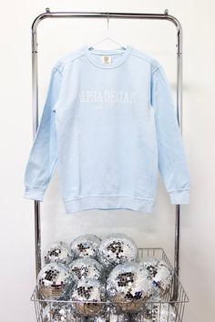 a bunch of silver balls sitting on top of a metal rack next to a blue sweatshirt