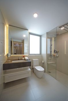 a bathroom with a sink, toilet and shower stall in the middle of the room