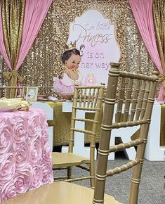 a baby shower is set up with pink flowers and gold sequins on the walls