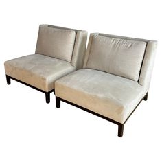 a pair of beige couches sitting next to each other on top of a white floor