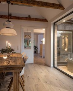 a wooden table sitting in front of a glass door with candles on top of it