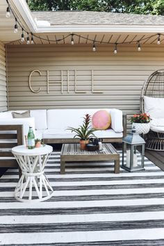 a white couch sitting on top of a black and white striped rug next to a wooden table