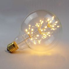 a light bulb that is turned on and has some lights in it, sitting on a white surface