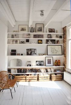 a white room with bookshelves and pictures on the wall