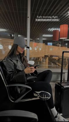 a woman is sitting in an airport waiting for her flight