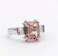 a pink diamond ring with three baguettes on each side