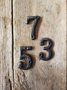 three metal numbers are placed on a wooden surface