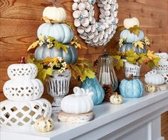 a table topped with vases filled with different types of pumpkins and fall leaves