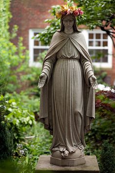 a statue of the virgin mary in a garden