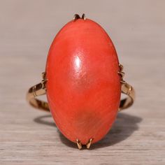 The Albion: Ladies 18k Gold Elongated Coral Cocktail Ring. Crafted In 18 Karat Yellow Gold, This Statement Ring Features A 22mm X 13.2mm Natural Coral Cabochon. The Ring Features A Delicate Filigree Design Underneath The Head Adding Subtle Character To The Ring. Currently, The Ring Is A Finger Size 6.5 And Is Able To Be Resized For An Additional Charge Upon Request. Elegant Oval Coral Rings, Coral Oval Jewelry For Weddings, Elegant Coral Oval Rings, High Luster Oval Yellow Gold Rings, High Luster Yellow Gold Oval Rings, Formal Coral Oval Jewelry, Natural Coral, Filigree Design, Cocktail Ring