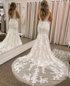 a woman is looking at her wedding dress in the mirror