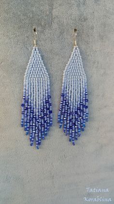 two pairs of blue and white beaded earrings on top of a gray surface,