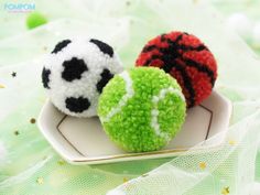 two small crocheted balls sitting on top of a white plate next to each other