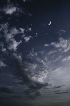 the night sky is full of stars and clouds, with one half moon visible in the distance