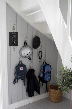 there is a coat rack on the wall in this room with many coats and backpacks