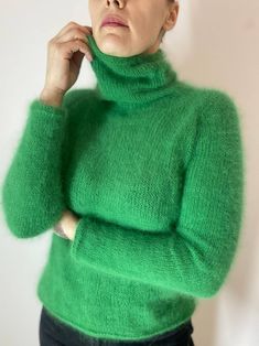 Stay cozy and stylish in this luxurious green angora wool sweater with a chic high collar. Handcrafted with the finest quality angora wool, this sweater is soft, warm, and perfect for chilly days. The timeless design and classic color make it a versatile piece for any wardrobe. green turtleneck look at the photo of flowers and choose which one you like. The color plate is shown in the photo. I offer a choice of 27 colors! The sweater in the photo is made in color No.10 If you did not find the co Green Funnel Neck Winter Sweater, Green Funnel Neck Sweater For Winter, Green Mohair Cozy Sweater, Elegant Green Winter Sweater, Cozy Green Mohair Sweater, Fitted Mohair Turtleneck Sweater, Green Mohair Knitted Sweater, Green Mohair Winter Sweater, Fitted Green Hand Knitted Sweater