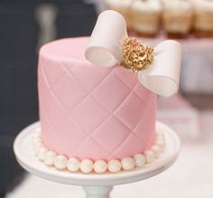 a pink and white cake sitting on top of a table