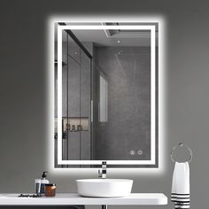 a bathroom with a sink, mirror and light on the wall above it's counter