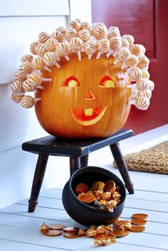 a pumpkin sitting on top of a chair next to a bowl filled with candy chips