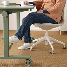 a person sitting at a desk with a laptop and coffee cup in front of them