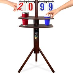 two people reaching for cups on a three tiered table with numbers and calendars