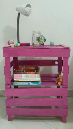 a pink table with books and a lamp on top