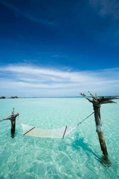 hammock tied to wooden posts in the ocean