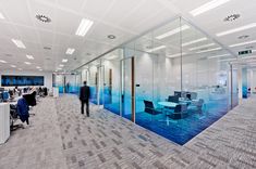 an office with glass walls and people working at desks