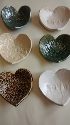 six heart shaped dishes sitting on top of a table