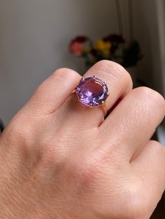 A huge 6 carat amethyst sits in a basket setting of 18k rose gold. This ring is truly a show stopper! The amethyst is synthetic (meaning created in a lab rather than in nature) and sparkles with light purple and blue undertones.  Details: Metal Purity -18k yellow gold (professionally acid tested to confirm) Ring size - 7.5 Weight - 5.3g Amethyst size - 14 mm diameter, 6 carats Ring Rise off of finger - 7.64 mm If this isn't your size, you are welcome to have it sized on your own, OR we can have Rose Gold Amethyst Ring With Gemstone, Rose Gold Amethyst Gemstone Ring, Luxury Solitaire Amethyst Ring As Gift, Fine Jewelry Rose Gold Round Amethyst Ring, Luxury Solitaire Amethyst Ring, Formal Rose Gold Amethyst Ring In 14k Gold, Elegant Rose Gold Solitaire Amethyst Ring, Rose Gold Amethyst Ring With Round Cut, Classic Rose Gold Amethyst Ring With Prong Setting